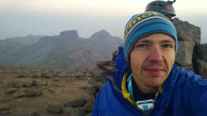 A selfie atop Wetterhorn Peak with a pile of boulders in the background
