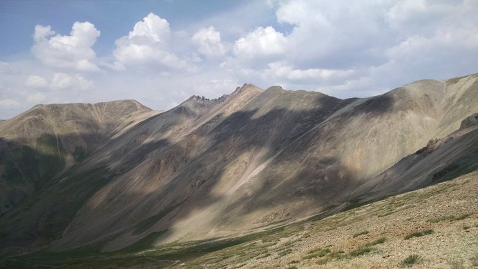 Clouds create patterns of dark and light in the basin below Redcloud Peak